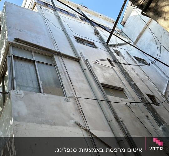 קירות בניין עם צינורות וכבלים חשמליים חיצוניים